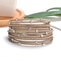 Detail of rose gold metal chain and beige leather bracelet with sparkling cubic zirconia - Khaki