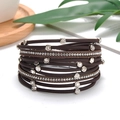 Close-up of layered brown leather bracelet with silver chains and sparkling crystals - Coffee