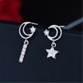 Macro shot of asymmetrical silver moon and star earrings with sparkling cubic zirconia - Asymmetric Star Moon Long (JED344)