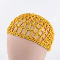 Detail of yellow crochet hairnet cap showing wide mesh pattern on a mannequin head - Turmeric