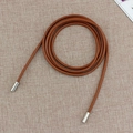 Schmale braune Leder-Taillenkette mit silbernen Metallspitzen auf beigem Netzgrund - Camel