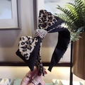 Leopard print bow headband with sparkling rhinestones on a stylish black fabric base - Small Dot Leopard
