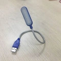 Luce notturna a LED USB blu portatile con collo in metallo flessibile su tavolo in legno - Blu