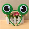 Close-up of green frog eye headband featuring plush fabric texture and 3D stuffed eyes - Green Frog