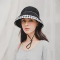 Detail view of cotton bucket hat featuring black and white plaid brim and adjustable wind rope - Black / M (56-58cm)