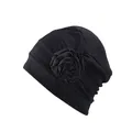 Details eines eleganten schwarzen Turbanhuts mit Plissee und großer Seitenblume - Schwarz