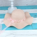Pink straw sun hat for women featuring wavy brim and delicate floral ribbon accents - Adult M / Light Pink
