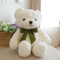 Oso de peluche color crema con lazo de cinta de seda verde sentado en un ambiente acogedor - Oso Con Lazo Blanco Nieve