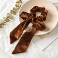 Brown velvet scrunchie with long ribbon bow on a decorative ceramic plate - Coffee