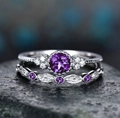 Macro shot of 2pcs vintage silver ring set with purple zircon stones on a dark rock - Purple