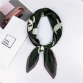 Détail d'un foulard en soie plissé vert avec motifs floraux noué avec style - Style 26 Plissé Motif LOVE Vert
