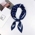 Détail d'un foulard plissé bleu à pois blancs noué, présenté sur un fond blanc propre - Style 13 Plissé Pois Bleu Marine