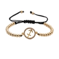 Detailed shot of Sagittarius zodiac charm with white zircon and gold beaded woven bracelet - Sagittarius