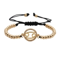 Detail of Cancer zodiac gold-plated charm on black woven adjustable bracelet - Cancer