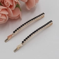 Pair of gold metal hair clips with dark blue rhinestones on a white background - Bobby Pin Black Rhinestone / Black