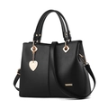 Women's black tote bag with gold hardware, heart charm, and detachable strap on white background - Black