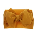 Detail view of mustard yellow baby headband featuring textured waffle fabric and large bow - Pre-tied Bow / Ginger Yellow