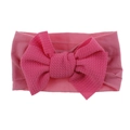 Detail of soft ribbed nylon baby headband with a large bright pink knotted bow - Dusty Rose with Magenta Bow