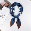 Detail van een geplooide marineblauwe zijden sjaal met witte patronen en bruine rand - Stijl 25 Geplooid LOVE Patroon Blauw