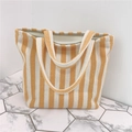 Dettaglio di una borsa tote in tela a righe spesse con cerniera e manici resistenti - Giallo chiaro