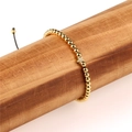 Verstellbares goldenes Perlenarmband mit Sternanhänger auf einem hölzernen Schmuckständer - Stern