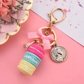 Macaron cake keychain with pink bow and golden Eiffel Tower charm on pink background - Fuchsia & Blue