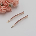 Paire de barrettes en métal doré avec strass roses sur fond blanc propre et net - Rouge Prune