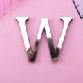Mirror gold acrylic letter W wall sticker with reflective finish on pink surface - Letter W