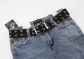 Detail of a blue denim fabric featuring a black double-grommet eyelet canvas belt - Black