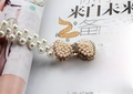 Macro detail of elastic pearl waist chain with rhinestone bow buckle on magazine - Large Bow Gold