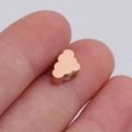Macro shot of rose gold cloud-shaped mirror stainless steel spacer bead held on a fingertip - 6x10mm / Rose Gold
