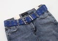 Dettaglio della cintura in tela blu con doppi occhielli e fibbia argento su jeans blu - Blu