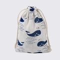 Beige cotton drawstring jewelry pouch featuring a blue whale and wave print pattern - Blue Whale