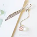 Detail of silver feather bookmark with a glass bead containing pink peach blossom - Pink Peach Blossoms