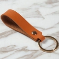 Orange leather keychain with premium grain texture and elegant gold metal ring - Brown
