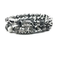 Detailed macro of Buddha head charm on black and white striped agate bead bracelet - Black Agate Texture