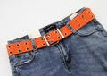 Close-up of bright orange double-grommet canvas belt on blue denim jeans - Orange
