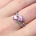 Silver color ring with double pink heart stones and small zircons on a woman's finger - Pink