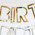 Golden and silver Happy Birthday banner bunting with metallic cardstock on white wall - Mirror Paper Hollow Gold