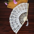 Elegant white lace folding fan with wooden ribs and white tassel on dark wood surface - 27CM White Rib White