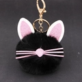 Close-up of black plush kitten keychain with pink glitter ears and gold metal clip - Black