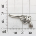 Detalle macro de un dije de pistola de metal plateado de 30mm sobre escala métrica - Pistola 9175 (3,5g)