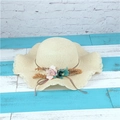 Creamy white straw sun hat featuring a wavy wide brim and colorful fabric flower decor - Beige