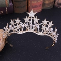 Detalle de corona de novia artesanal con estrellas de cristal y perlas sobre fondo vintage - Hecho a mano / Dorado