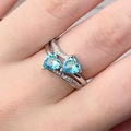 Elegant silver ring featuring double heart-shaped light blue gemstones and diamond accents - US 6 / Aqua
