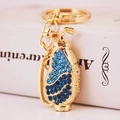 Golden golf bag keychain with blue crystals and clubs on a clean white desk - Blue