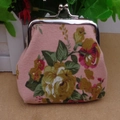 Close-up of pink floral canvas coin purse with silver metal ball clasp and rose pattern - Pink
