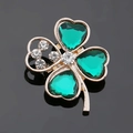 Detailed macro shot of a gold four-leaf clover brooch with green resin heart gems - Clover - Green Acrylic