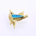 Macro detail of a golden hummingbird pendant with vibrant blue opal inlay craftsmanship - Gold Blue Opal