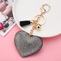 Detail of heart rhinestone keychain with black tassel and gold hardware on white plate - Silver Black